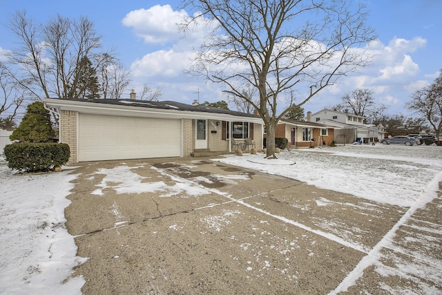 view of front of home with brick siding, driveway, and a garage