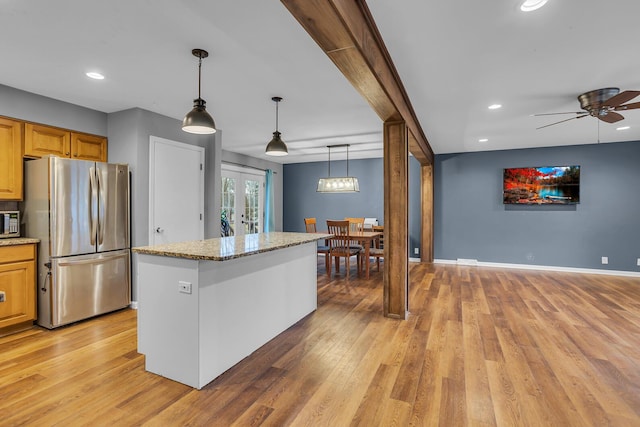 kitchen with light stone counters, baseboards, french doors, appliances with stainless steel finishes, and light wood-type flooring