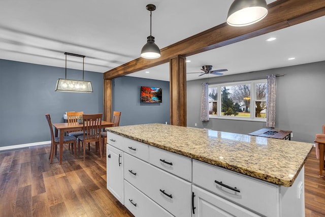 kitchen with light stone countertops, decorative light fixtures, beamed ceiling, dark wood-style floors, and white cabinets