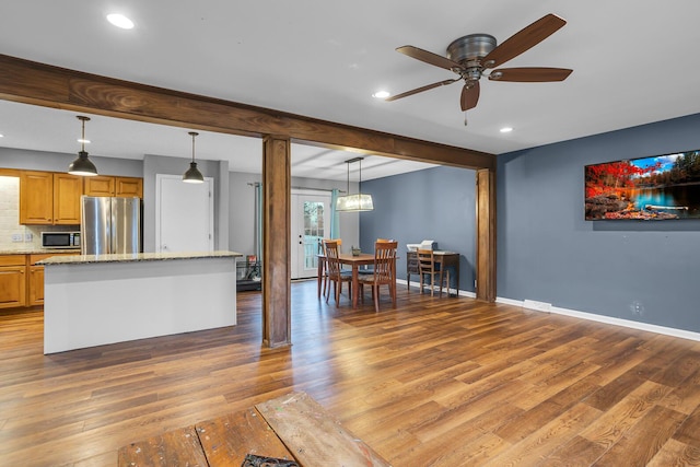 1307 Winston Dr, Jackson, MI 49203 - kitchen with light stone counters, light wood-type flooring, baseboards, and appliances with stainless steel finishes