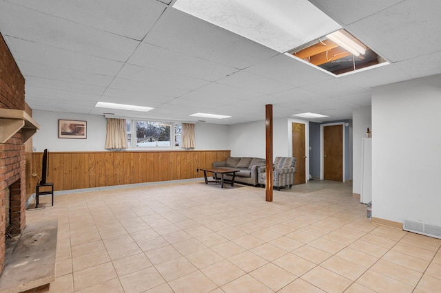 1307 Winston Dr, Jackson, MI 49203 - basement featuring a wainscoted wall, a paneled ceiling, wooden walls, and visible vents