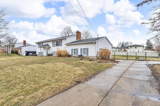 1307 Winston Dr, Jackson, MI 49203 - bi-level home featuring a gate, a chimney, a front lawn, and fence