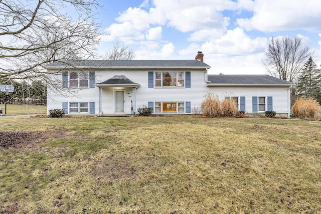 raised ranch featuring a front lawn and a chimney