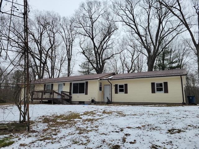 ranch-style home with metal roof and a deck