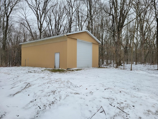 snow covered garage featuring a garage