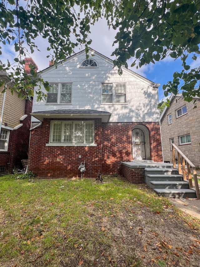 view of front of home featuring brick siding and a front yard