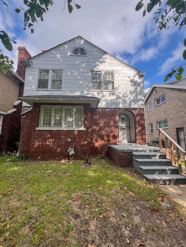 view of front of property with brick siding and a front lawn