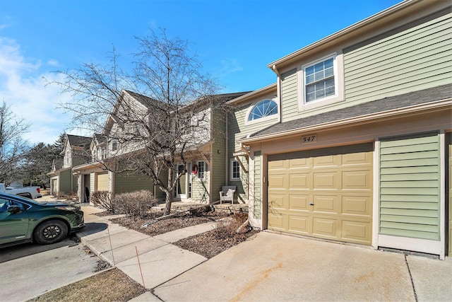 view of property featuring concrete driveway and an attached garage