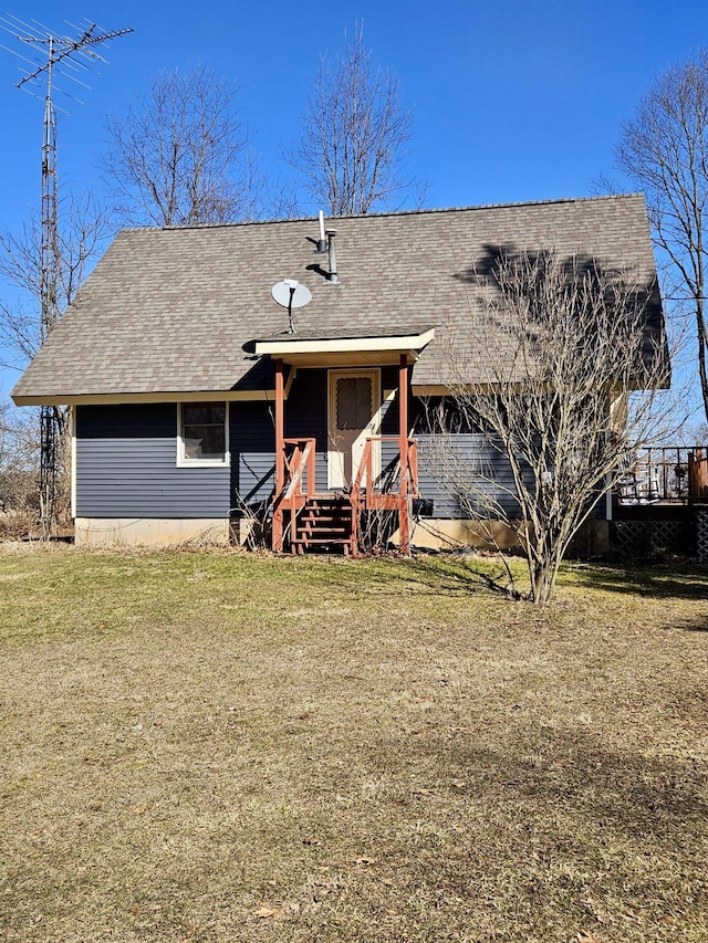 view of front of home with a front yard and roof with shingles