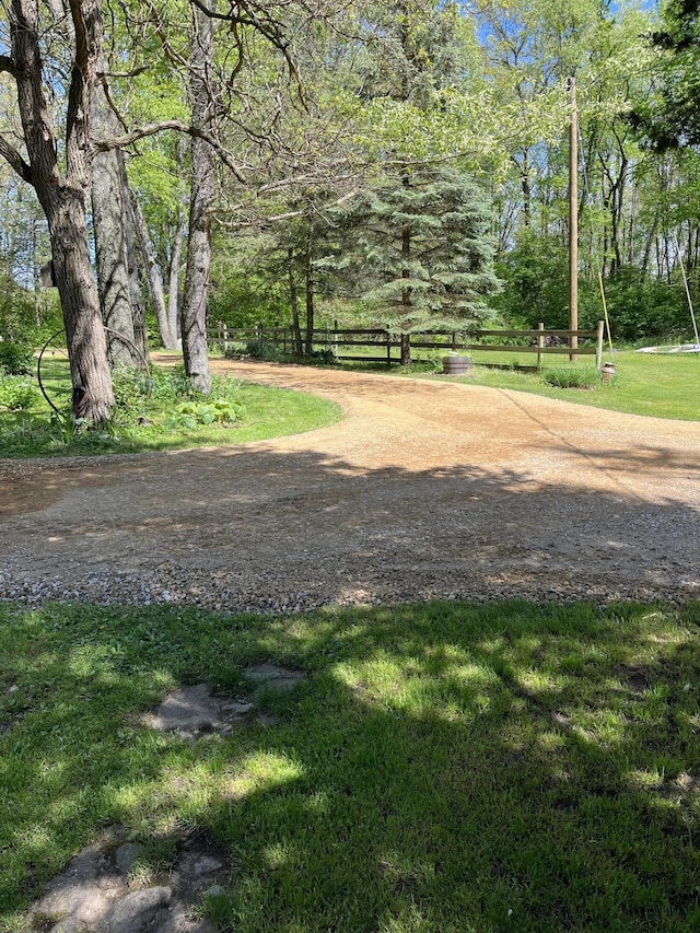 view of property's community featuring a yard and fence