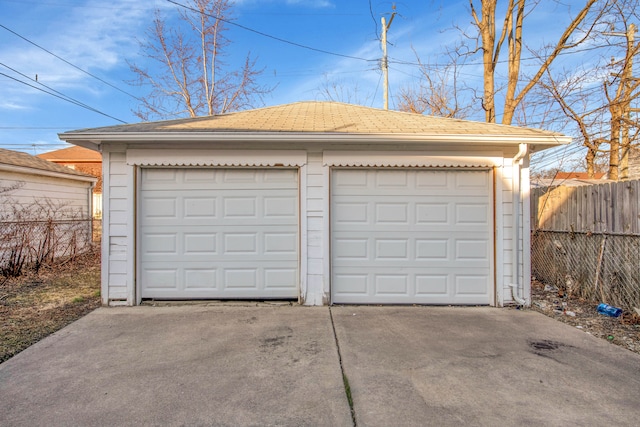 detached garage featuring fence