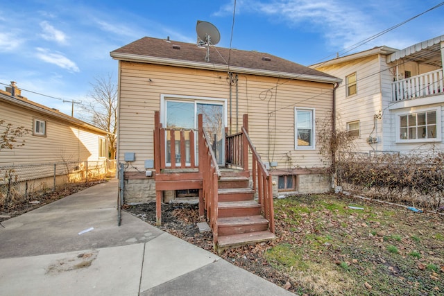 back of property featuring a patio, roof with shingles, and fence