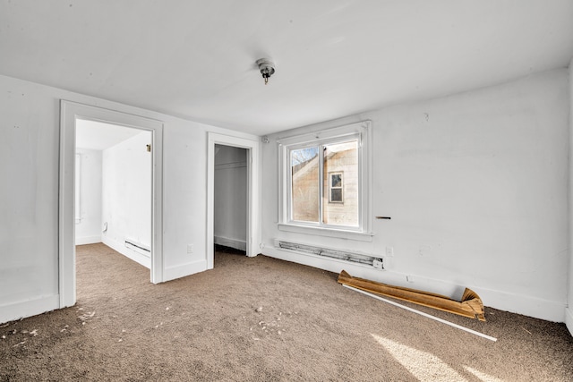 unfurnished bedroom with a closet, baseboards, and a baseboard heating unit