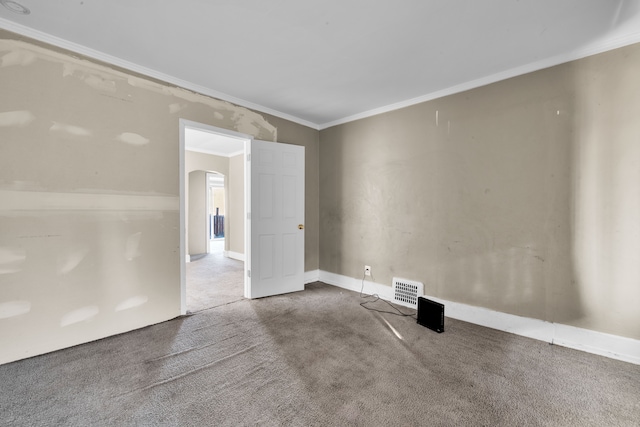 empty room featuring arched walkways, carpet flooring, crown molding, and visible vents