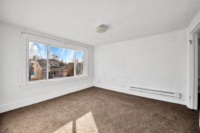 spare room with baseboards, baseboard heating, and carpet floors