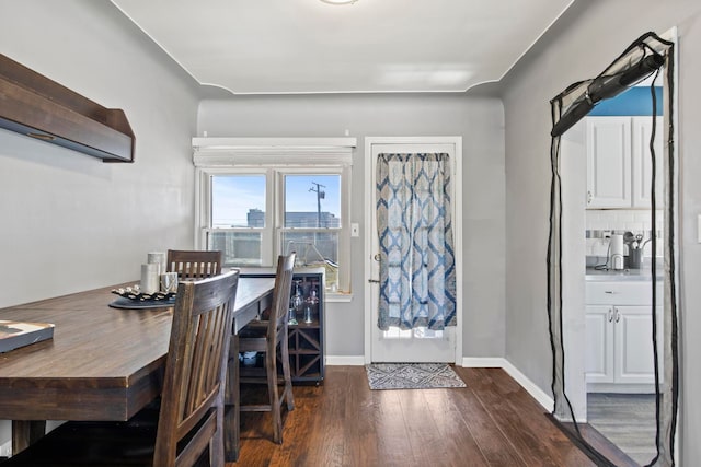 dining room with dark wood-type flooring and baseboards