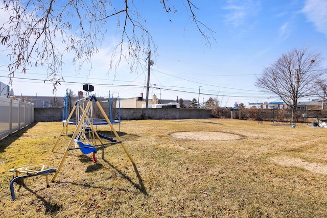 view of yard with a fenced backyard, a playground, and a trampoline