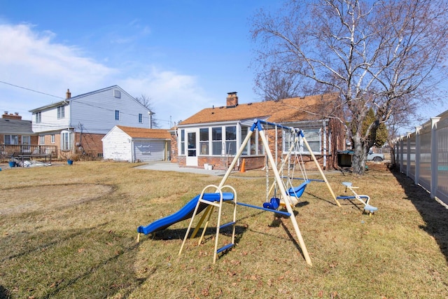 back of property with fence, a playground, a yard, brick siding, and a chimney