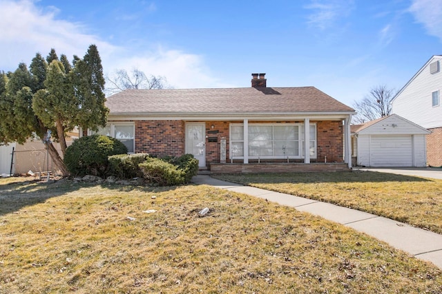 ranch-style home with an outbuilding, brick siding, a detached garage, and a front lawn