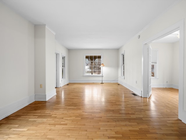 spare room featuring visible vents, crown molding, and light wood-type flooring