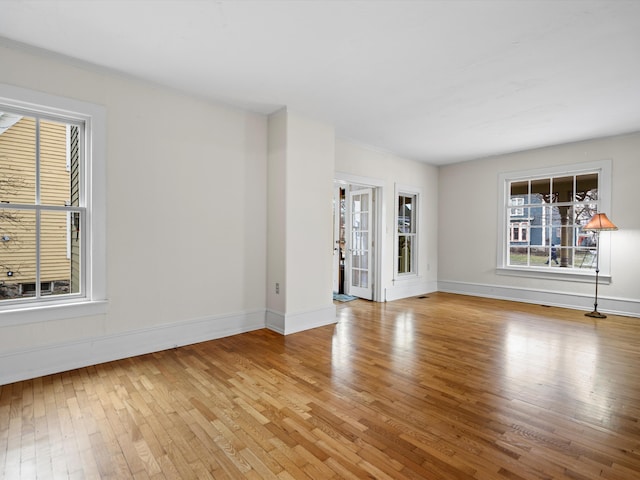 empty room with baseboards and light wood-style floors