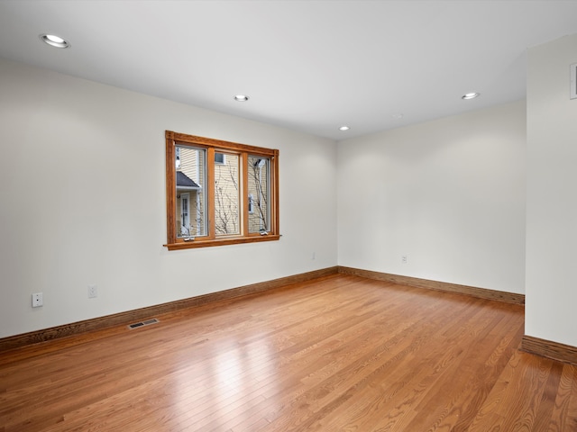 spare room featuring visible vents, recessed lighting, baseboards, and wood finished floors