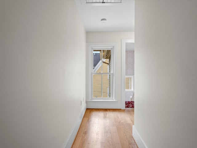 hall featuring baseboards and light wood-style floors