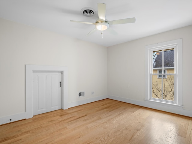 unfurnished room with light wood finished floors, visible vents, and baseboards