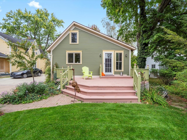 back of property with a deck and a yard