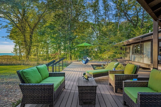 wooden terrace with an outdoor living space and a water view