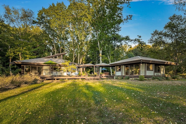 rear view of property with a yard and a wooden deck