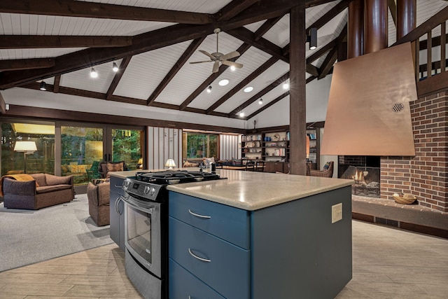 kitchen featuring blue cabinetry, a brick fireplace, open floor plan, light countertops, and gas stove