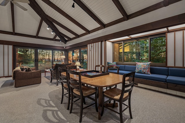 carpeted dining area featuring beam ceiling, track lighting, and a ceiling fan