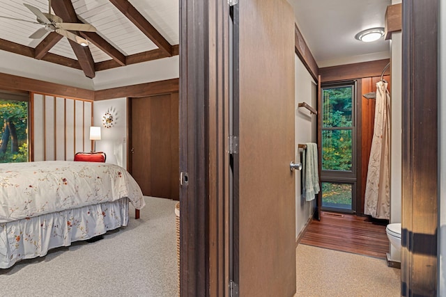 carpeted bedroom featuring beamed ceiling