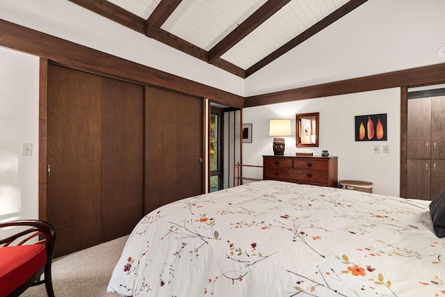 carpeted bedroom with a closet and vaulted ceiling with beams