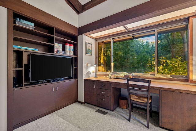 office area with light colored carpet, visible vents, and built in desk