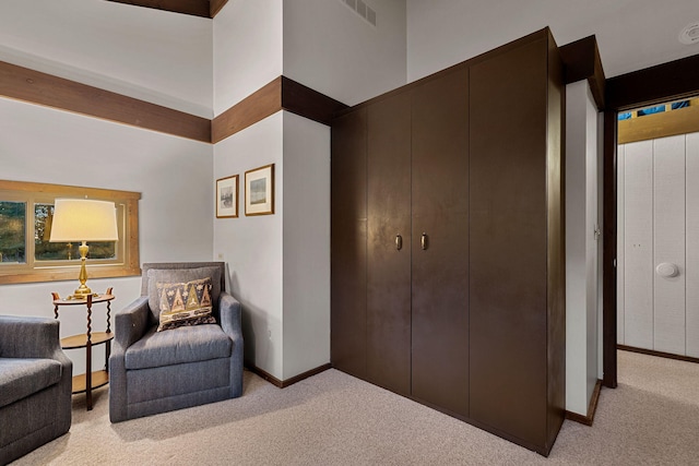 sitting room featuring light carpet, visible vents, and baseboards