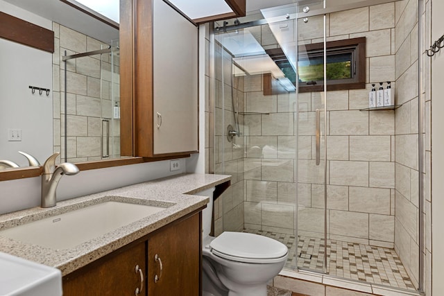 bathroom featuring a stall shower, toilet, and vanity