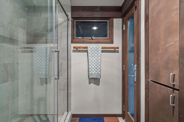 full bathroom with a shower stall and baseboards