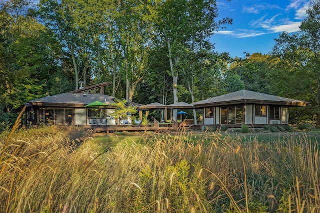 rear view of house with a sunroom and a wooden deck