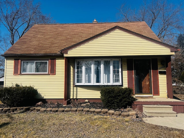 view of front of property with a chimney and a shingled roof