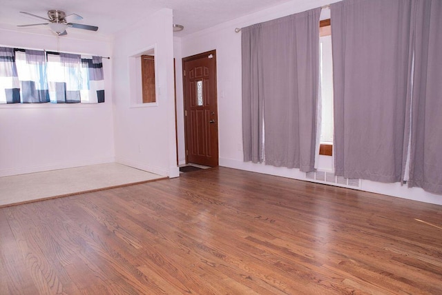 unfurnished room with visible vents, a ceiling fan, and wood finished floors