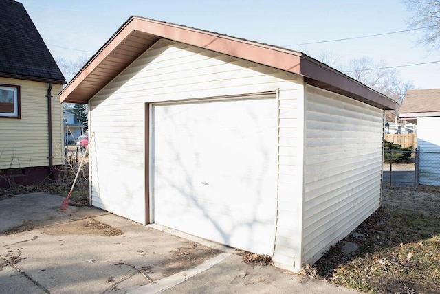 view of outbuilding featuring an outbuilding, driveway, and fence