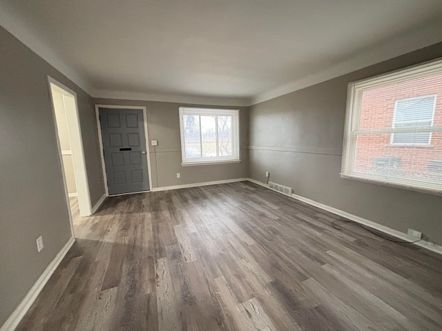 interior space featuring dark wood finished floors, visible vents, and baseboards