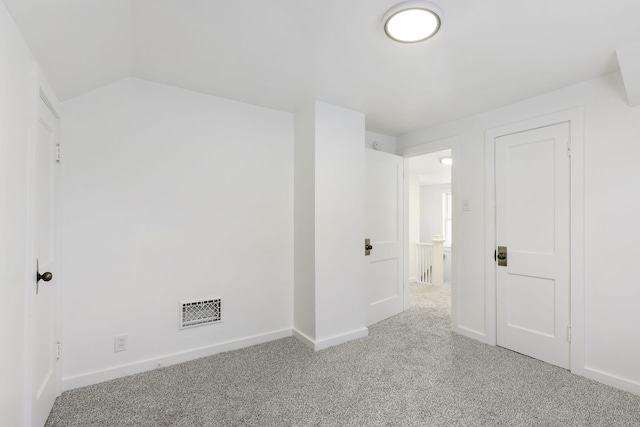 interior space featuring vaulted ceiling, baseboards, visible vents, and carpet floors