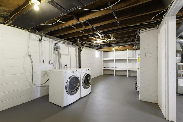 clothes washing area with washer and dryer, laundry area, and gas water heater