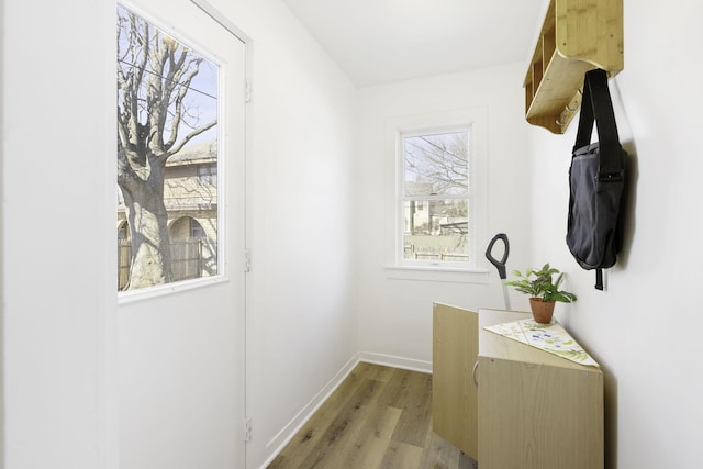 corridor with light wood-style flooring and baseboards