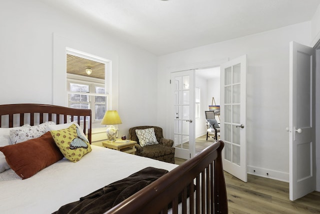 bedroom featuring light wood-type flooring, french doors, and baseboards