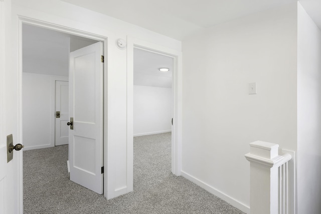 hall with carpet flooring and baseboards