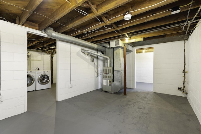 unfinished basement featuring visible vents, heating unit, and independent washer and dryer